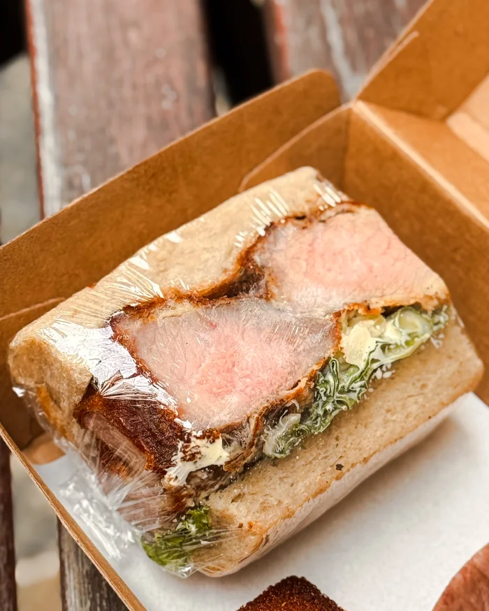 Sourdough pork katsu sando in a kraft takeaway box at Wild Honey Pie