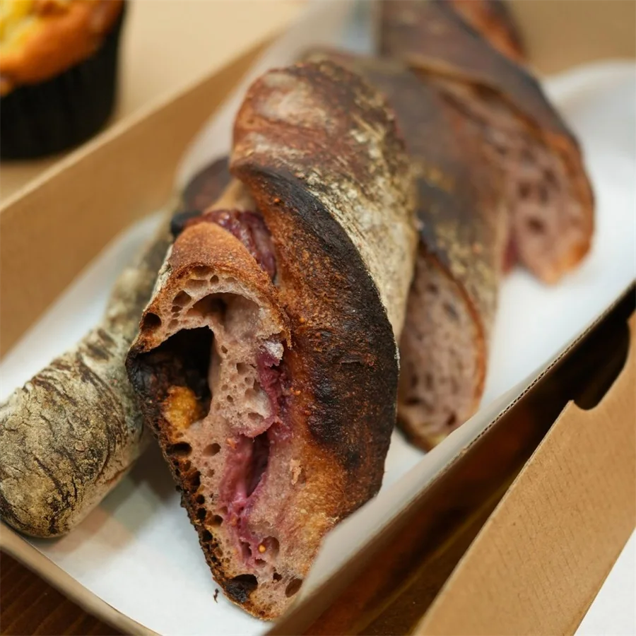 Red wine baguette with cranberry, walnut and cream cheese, cut to show the open crumb